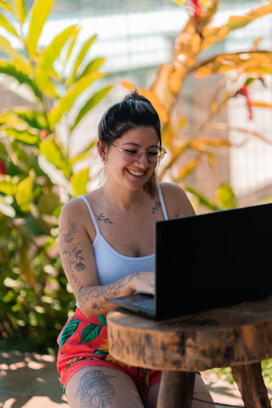 a woman sitting on a bench with a laptop