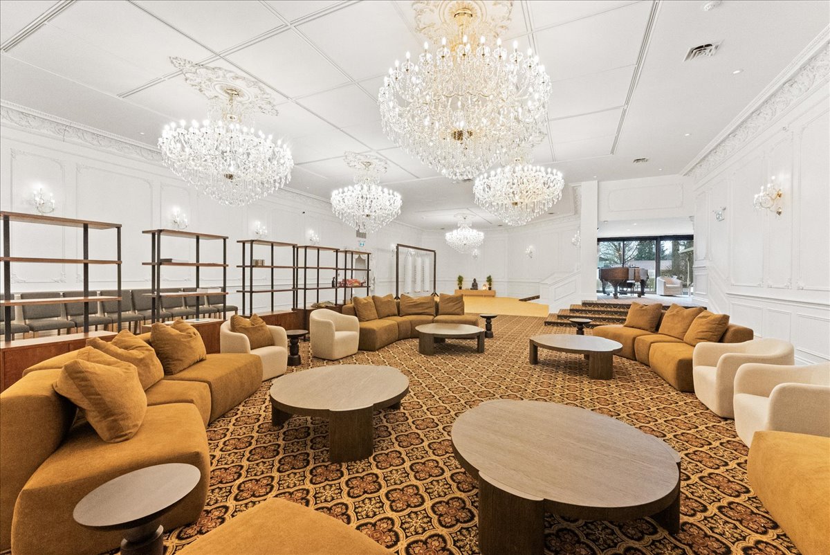 A large communal lounge at Rodman Hall, seating arranged in groups beneath chandeliers