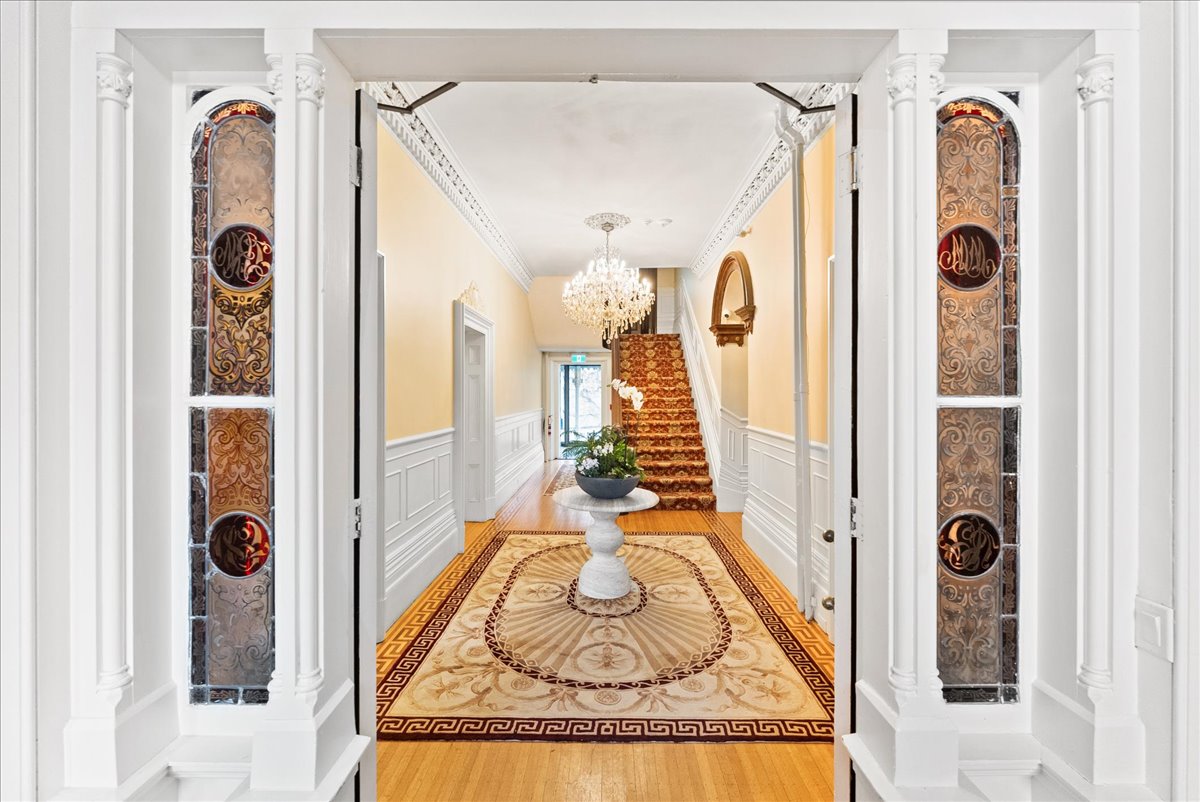 The entry hall at Rodman Hall, with its staircase, chandelier and stained glass