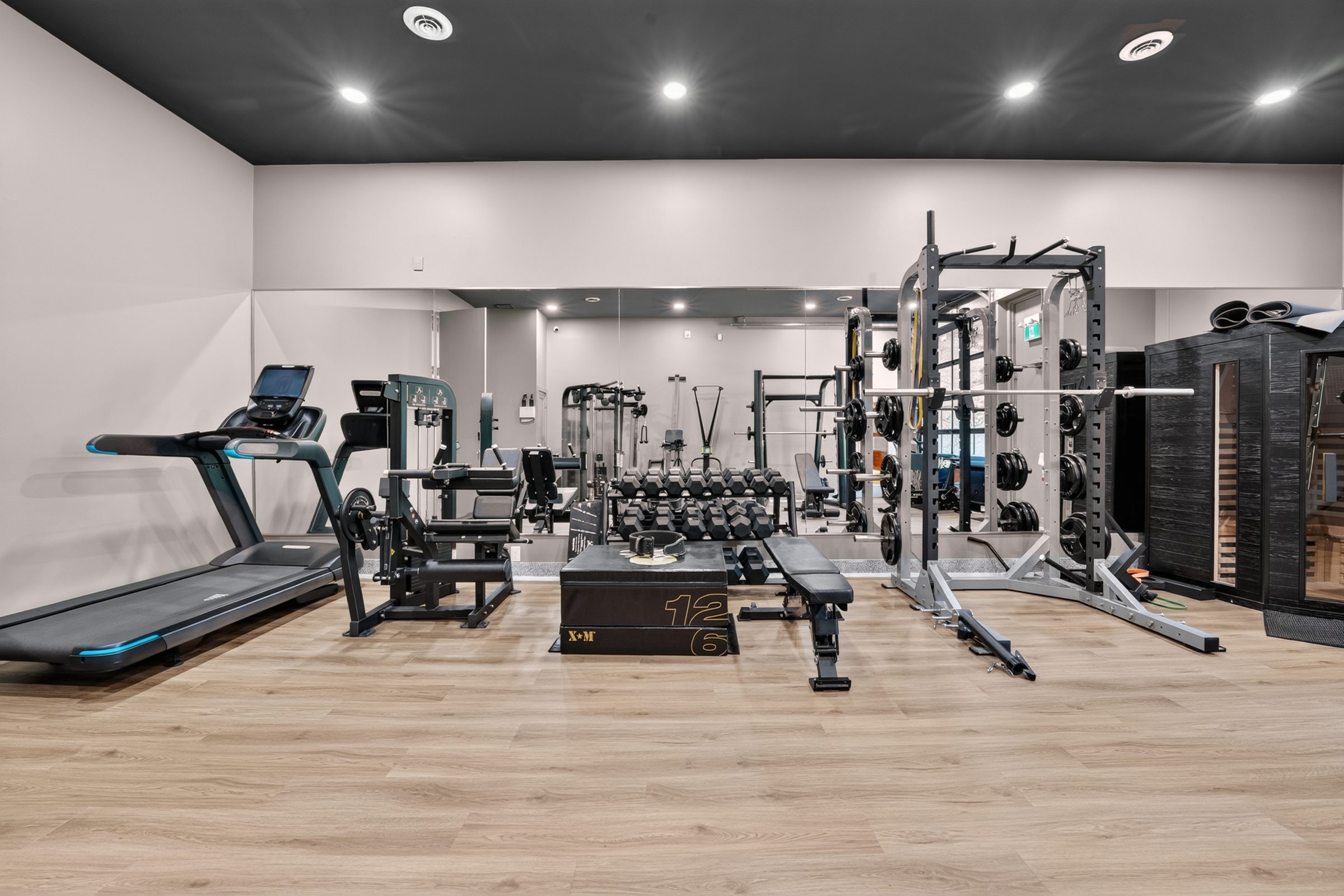The on-site gym at Rodman Hall, with free weights, a squat rack, cardio machines and an infrared sauna cabin